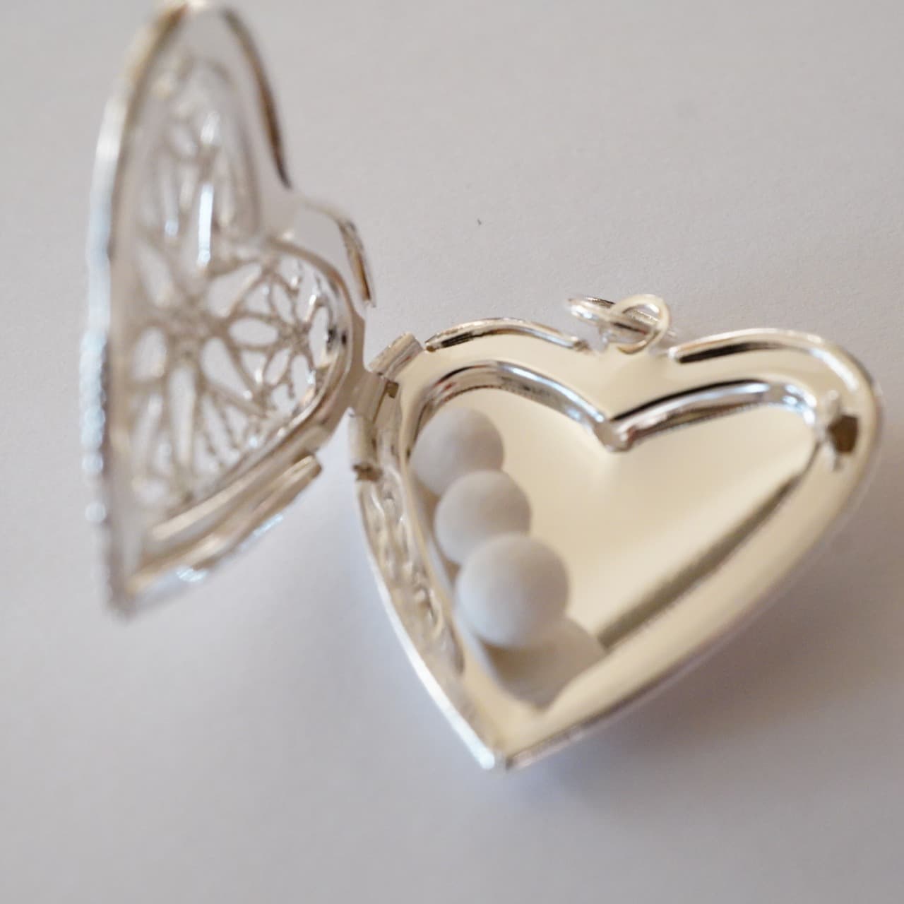 中に白い香り玉が３個入ったシルバーのアロマハート型ロケット。